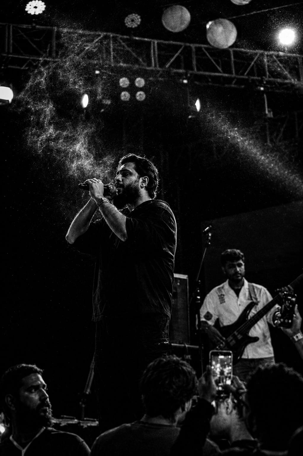 Black and white live music photograph of a singer lit from behind on stage